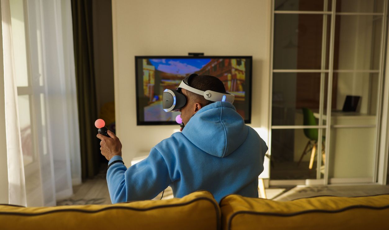 Experience immersive virtual reality gaming with headphones and controllers in a cozy living room setting