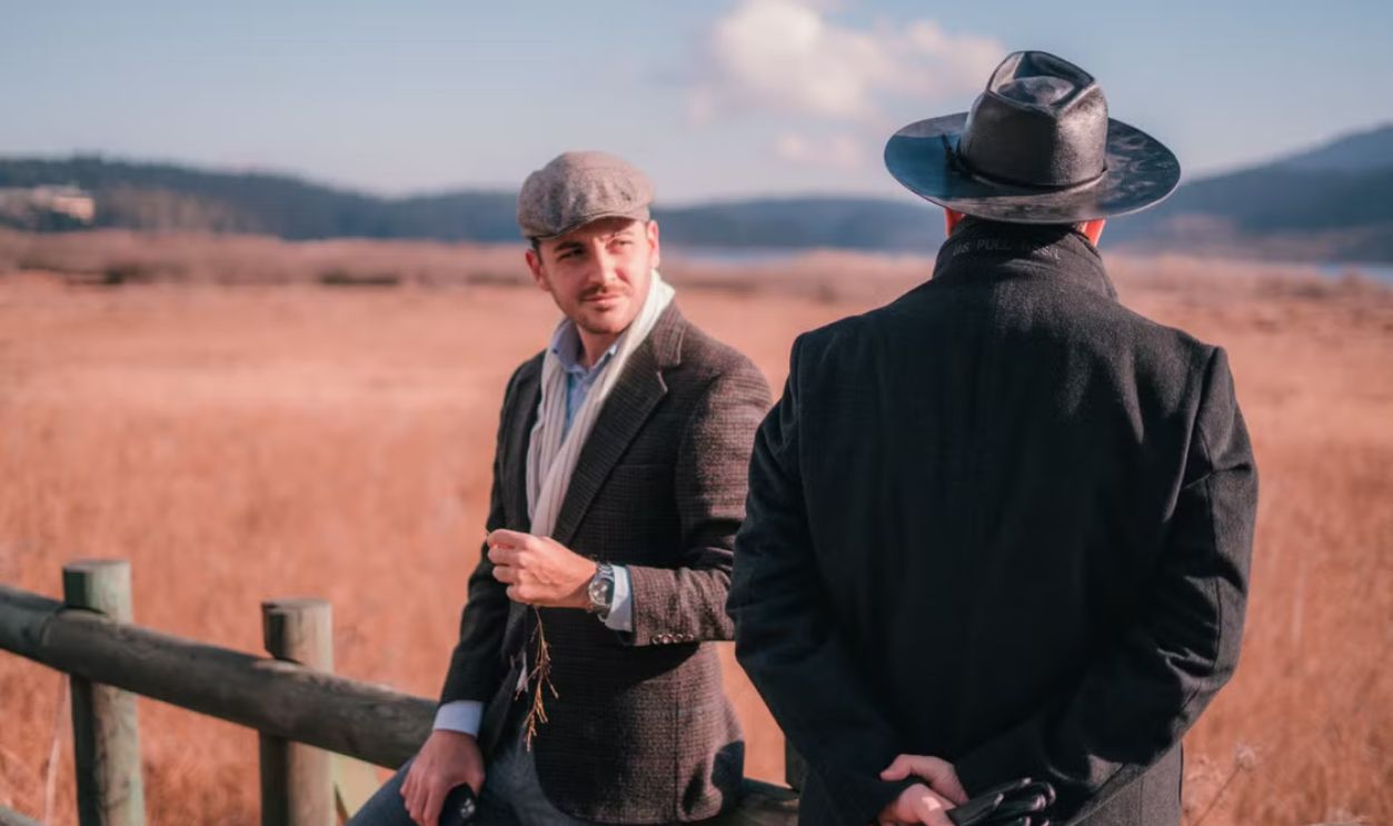 Two men in classic attire converse in Bolu's picturesque countryside, Turkey.