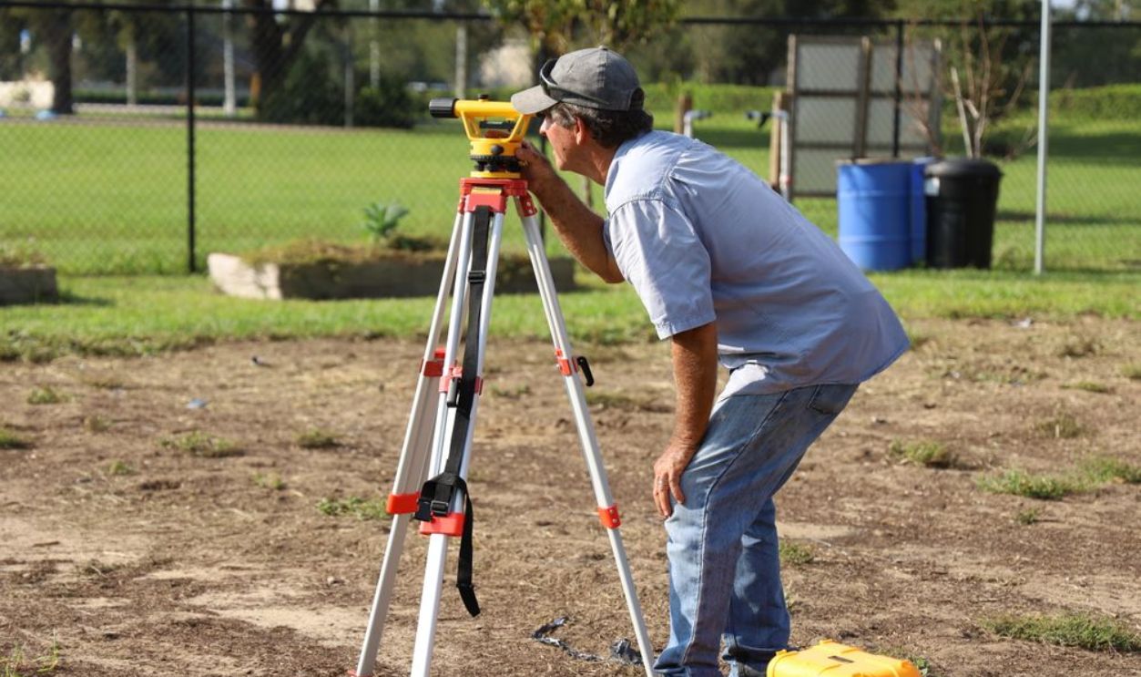 A land surveyor at work using equipment on a field in Tavares, Florida.