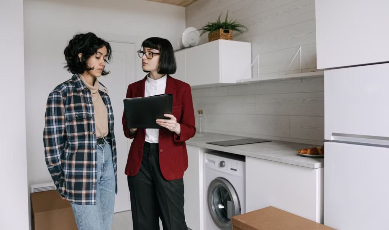 Real estate agent discussing home details with a client in a modern kitchen setting