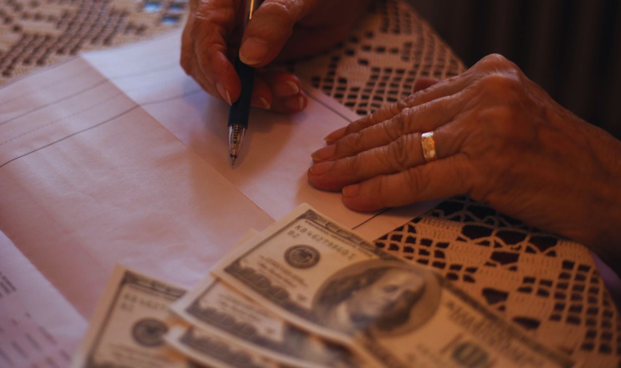 Close-up of unrecognizable senior woman doing finances at home.