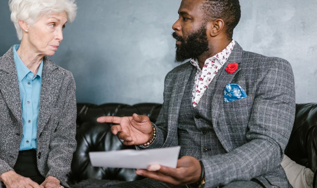 A focused business meeting between two colleagues discussing documents inside a modern office
