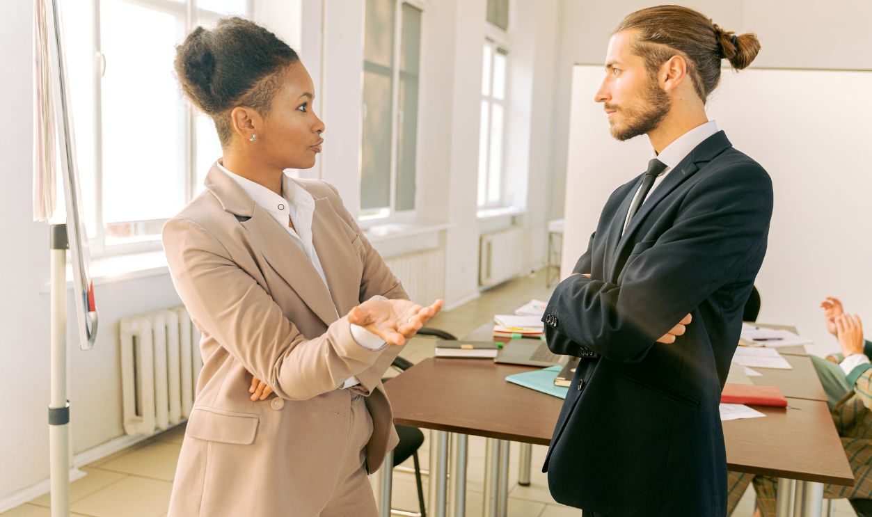 Business professionals in conversation during a meeting in a modern office environment.