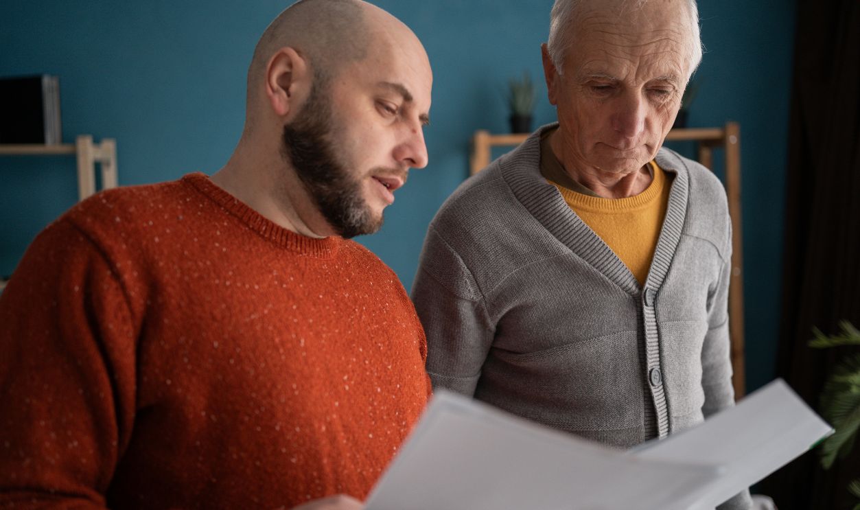 Accounting, finance or refund, mortgage and tax. Senior father with adult son in home reading documents for bank payment. copy space