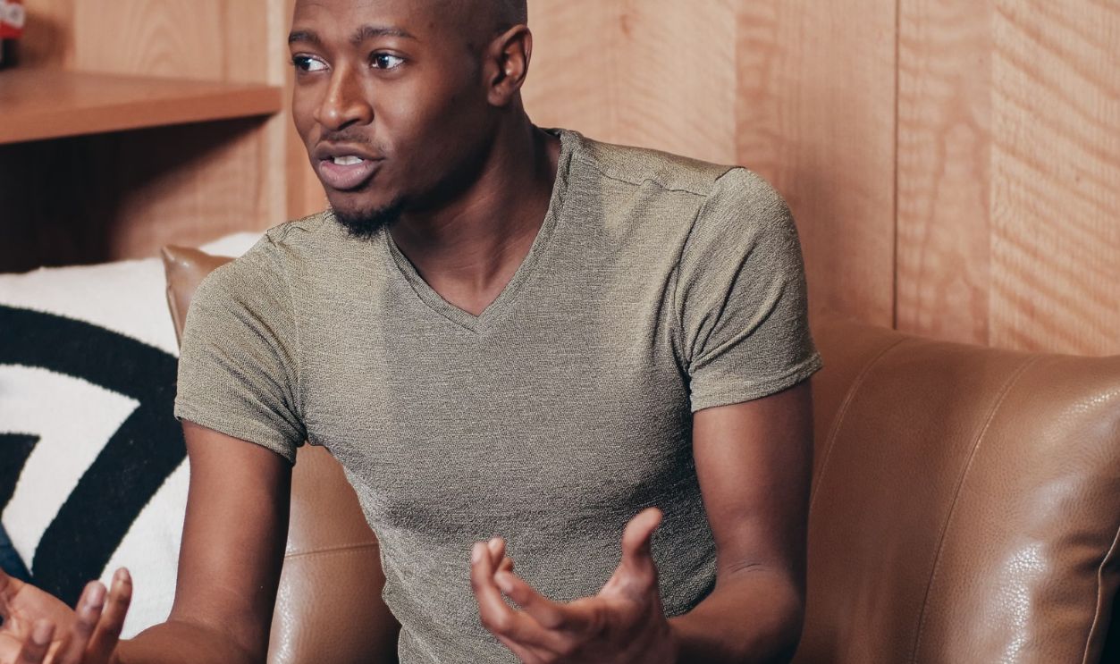 Black man sitting and talking during an office meeting indoors