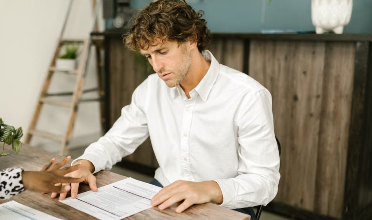 Two professionals discussing financial documents in an office setting