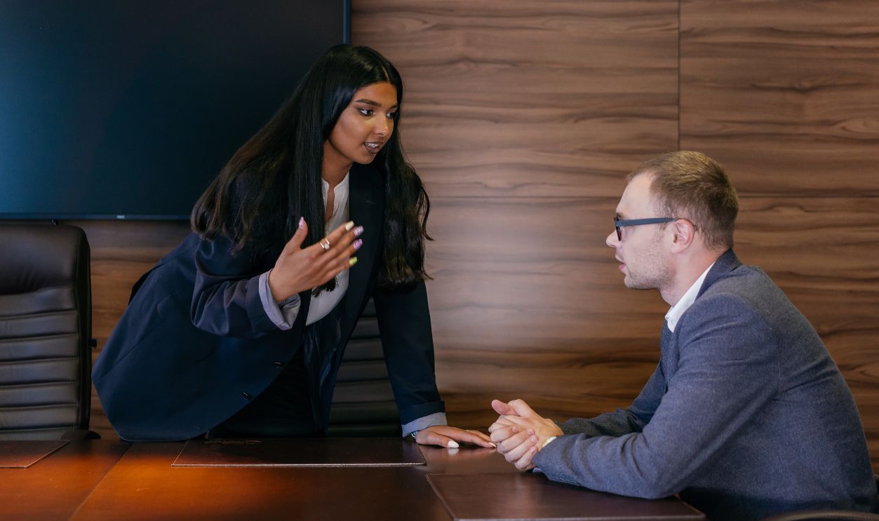 Two professionals having a discussion in a sleek conference room