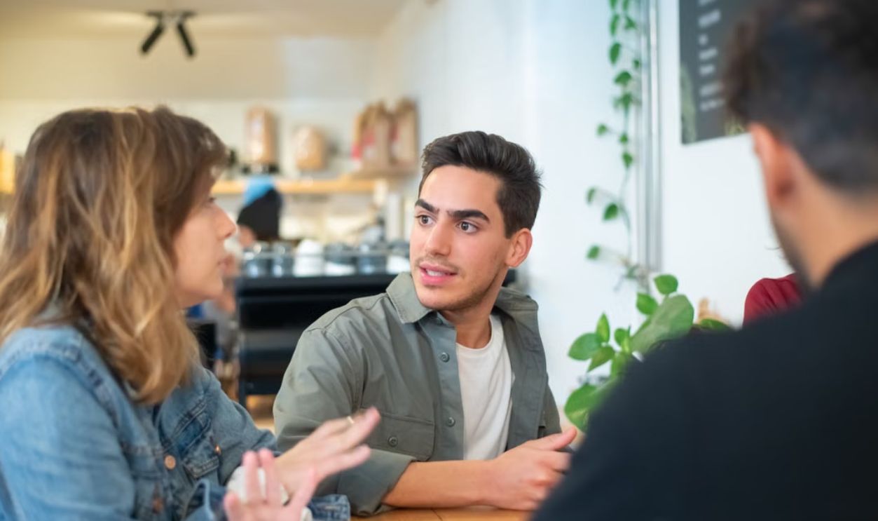 Young adults engaging in a lively discussion at a cozy cafe setting