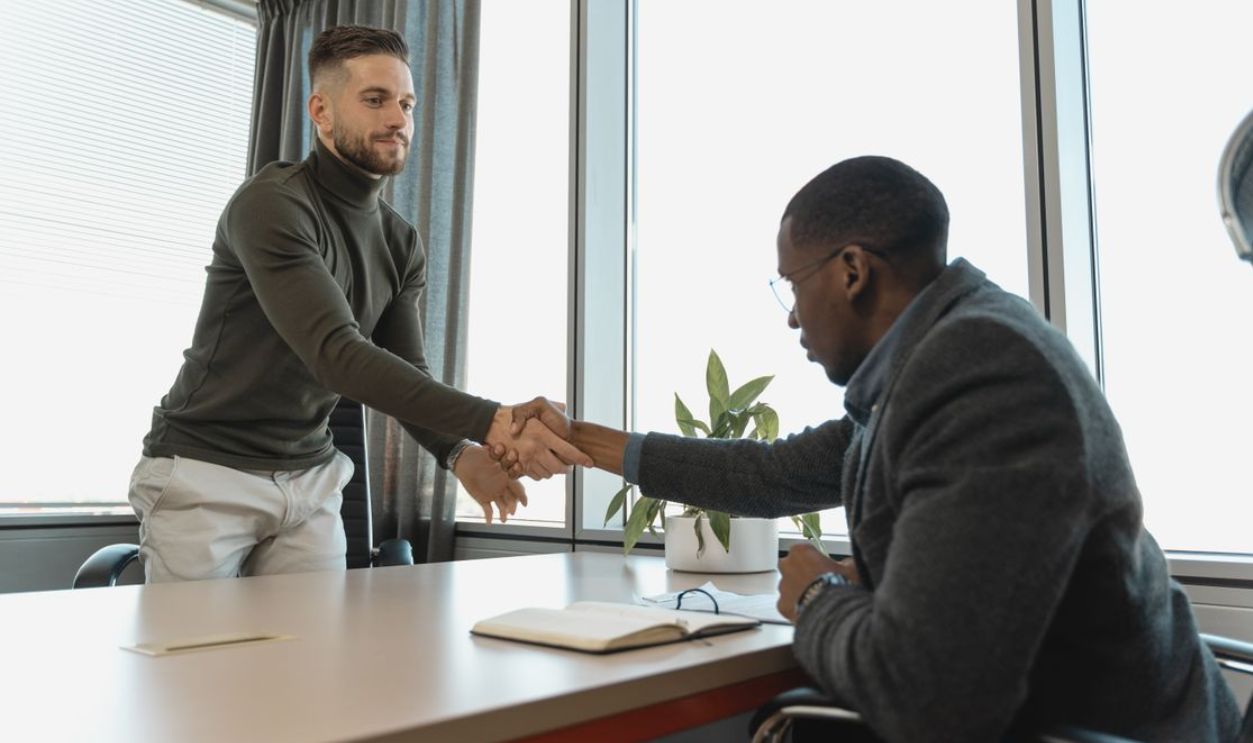 Two businessmen shaking hands in a modern office after a successful meeting or interview