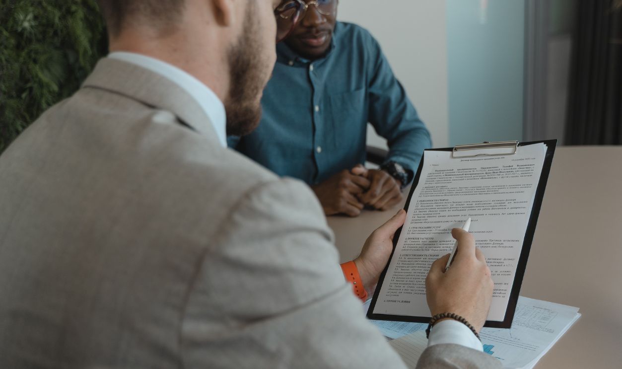 A recruiter reviews a candidate's documents during a job interview in a modern office setting