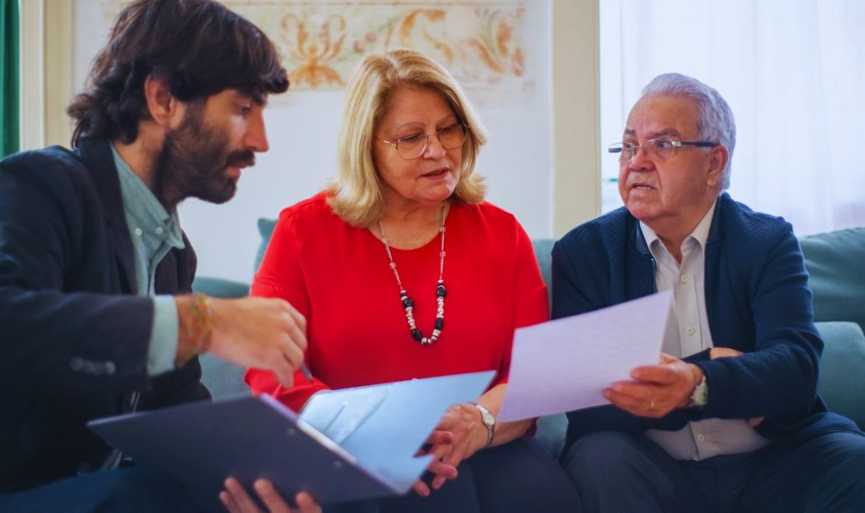 Senior couple consulting with a professional advisor, discussing documents indoors