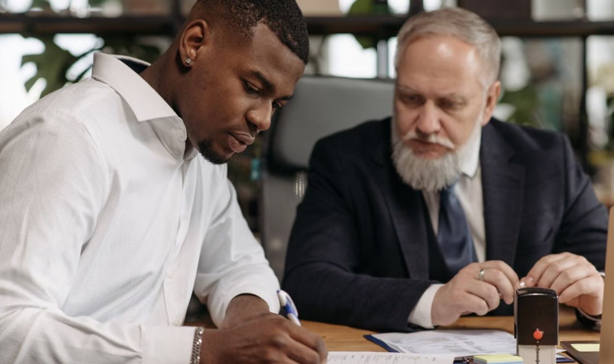Two businessmen collaborating in an office setting, focused on document review and strategic planning.