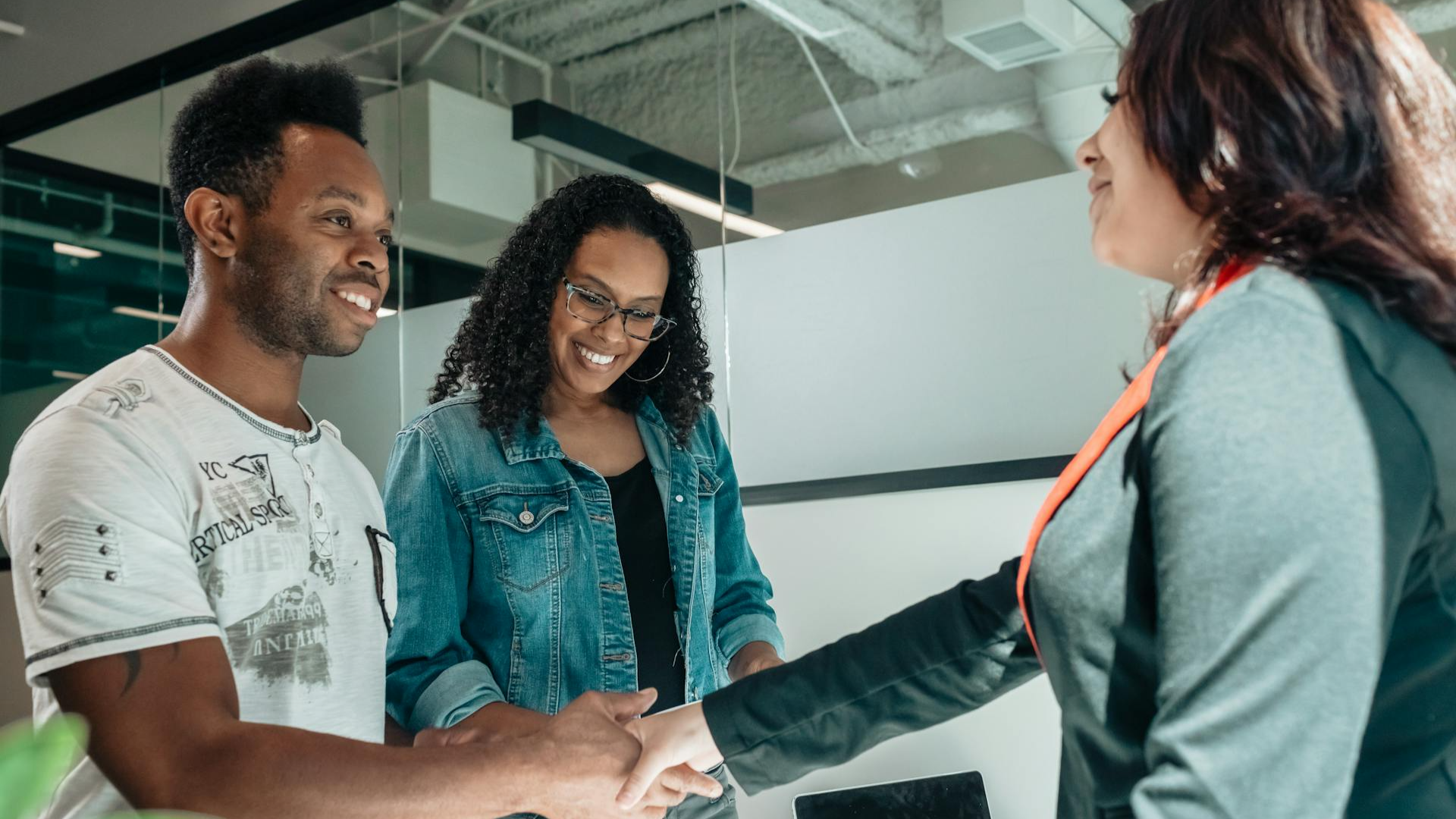 Smiling couple shaking hands with advisor 