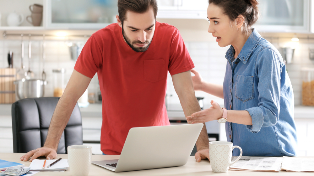 Young couple having argument about family budget in kitchen