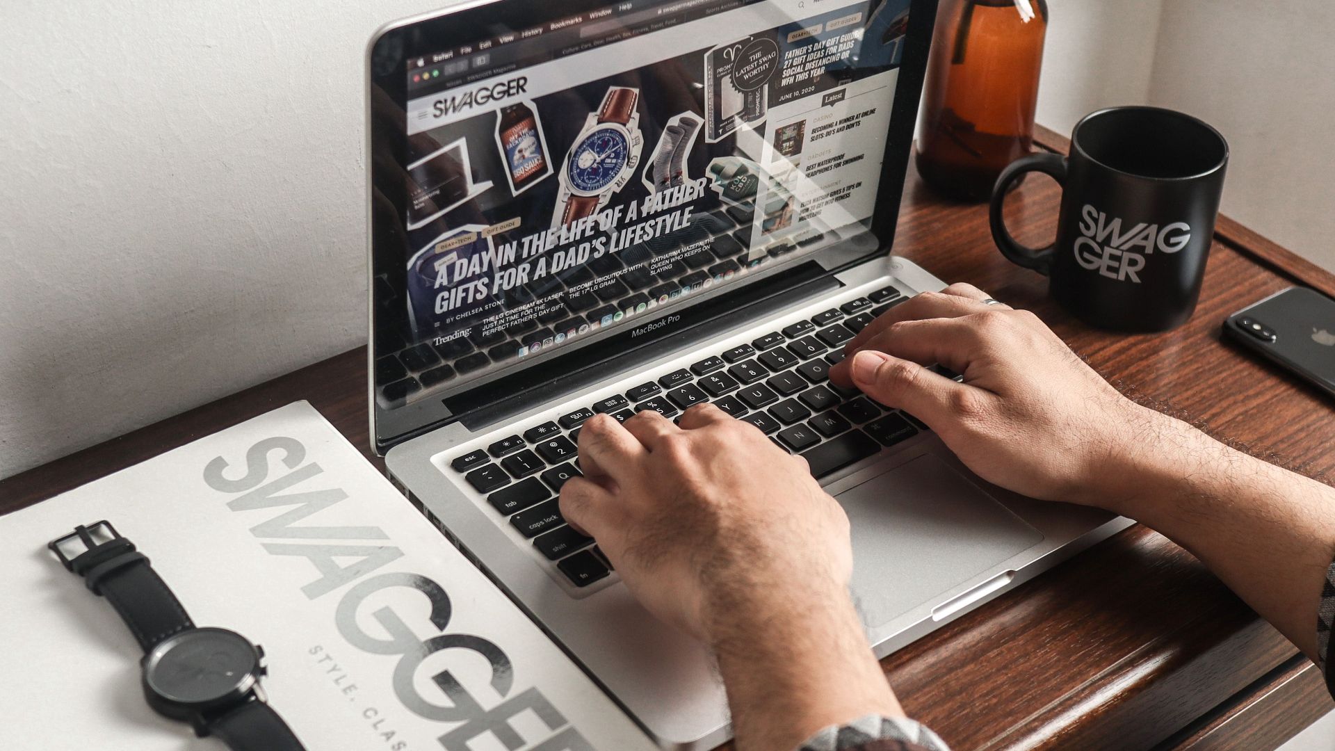 A person working on a laptop at a desk with a watch and mug, perfect for a productivity concept.