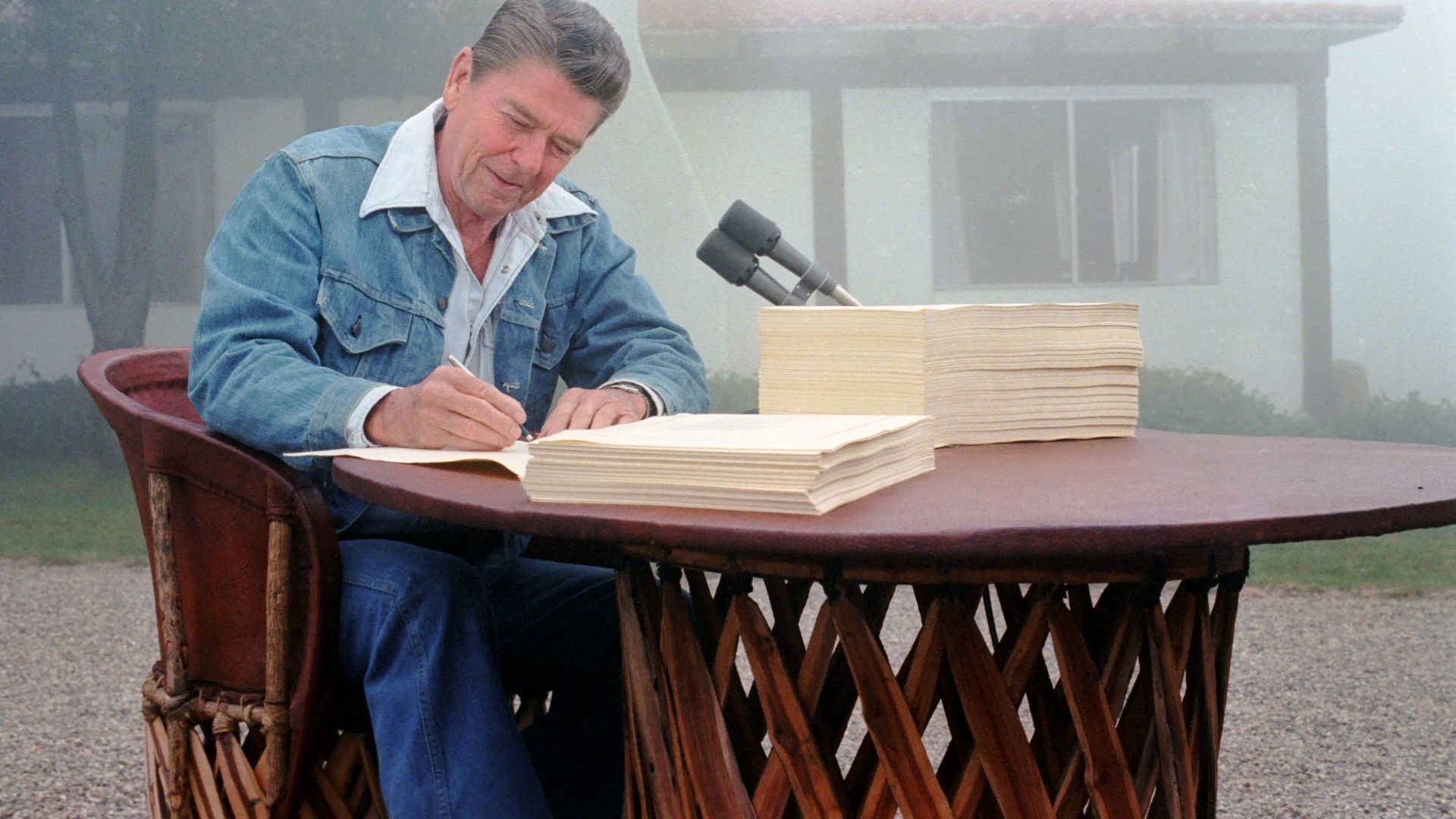 President Ronald Reagan signing the Economic Recovery Tax Act of 1981 and the Omnibus Budget Reconciliation Act of 1981 at his Santa Barbara, California ranch, Rancho del Cielo, 13 August 1981. Photograph by official White House photographer, Karl Schumac