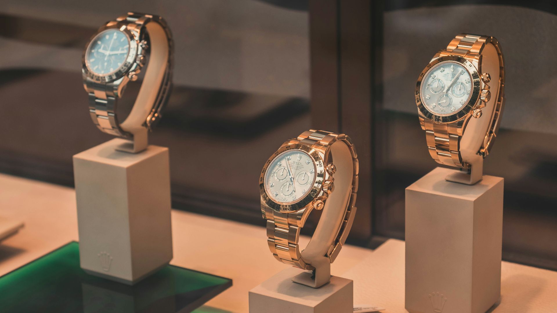 three round silver-colored chronograph watches on white mounts