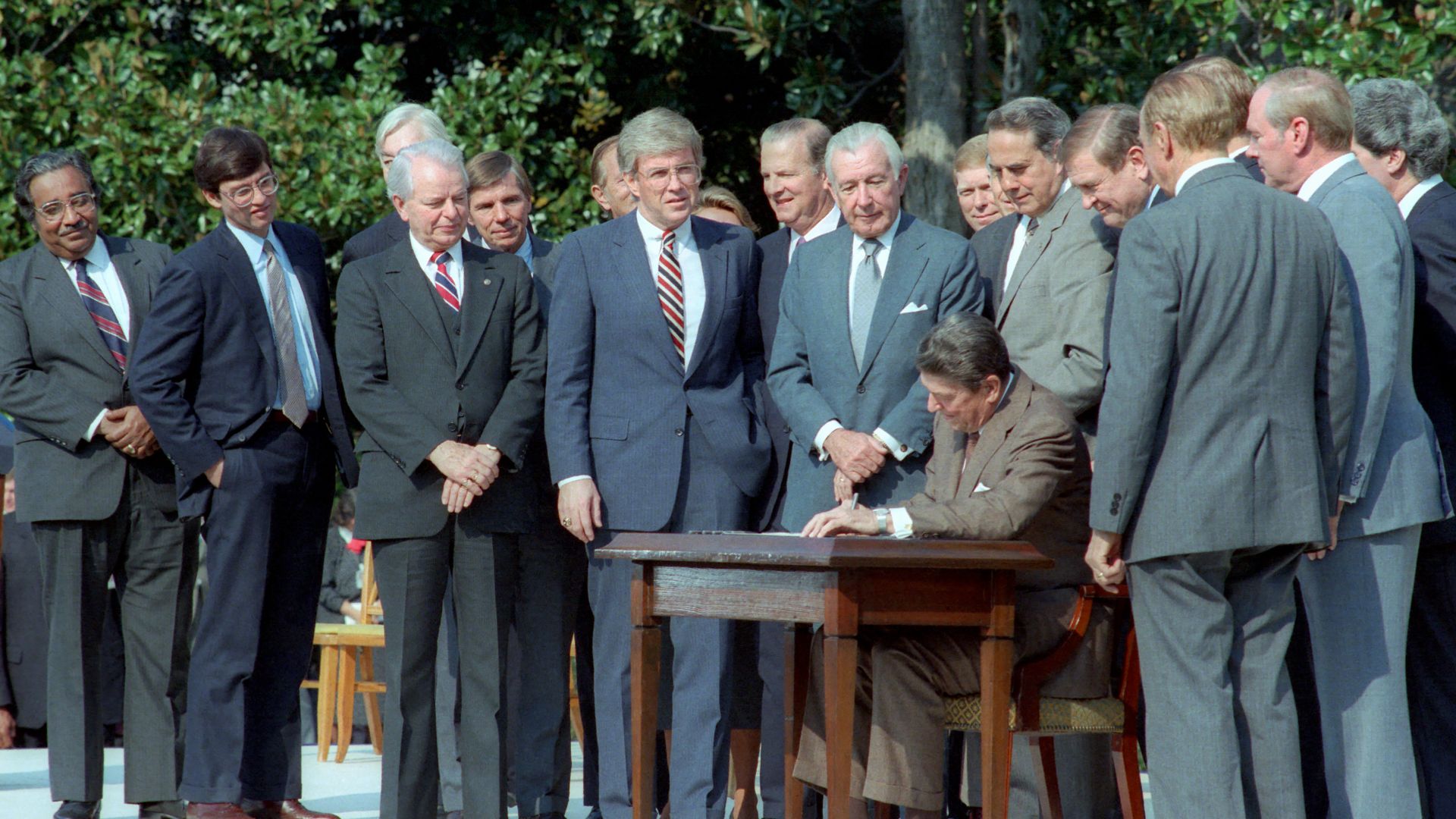 File:President Ronald Reagan Signing The Tax Reform Act of 1986 with Members of Congress and White House Staff Present on The South Lawn Dole Moynihan Kemp Byrd Regan Rostenkowski Thurmo - DPLA - 0ee37d5f41724395407d4df0f7116853.jpg