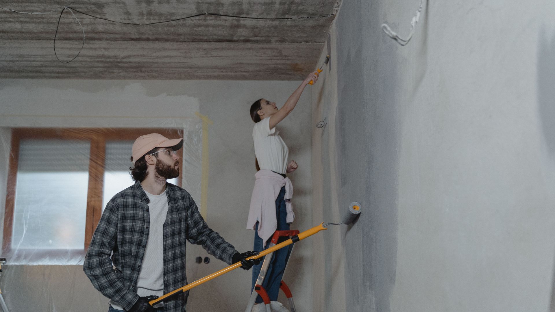 A couple painting a room together, highlighting teamwork in home renovation.