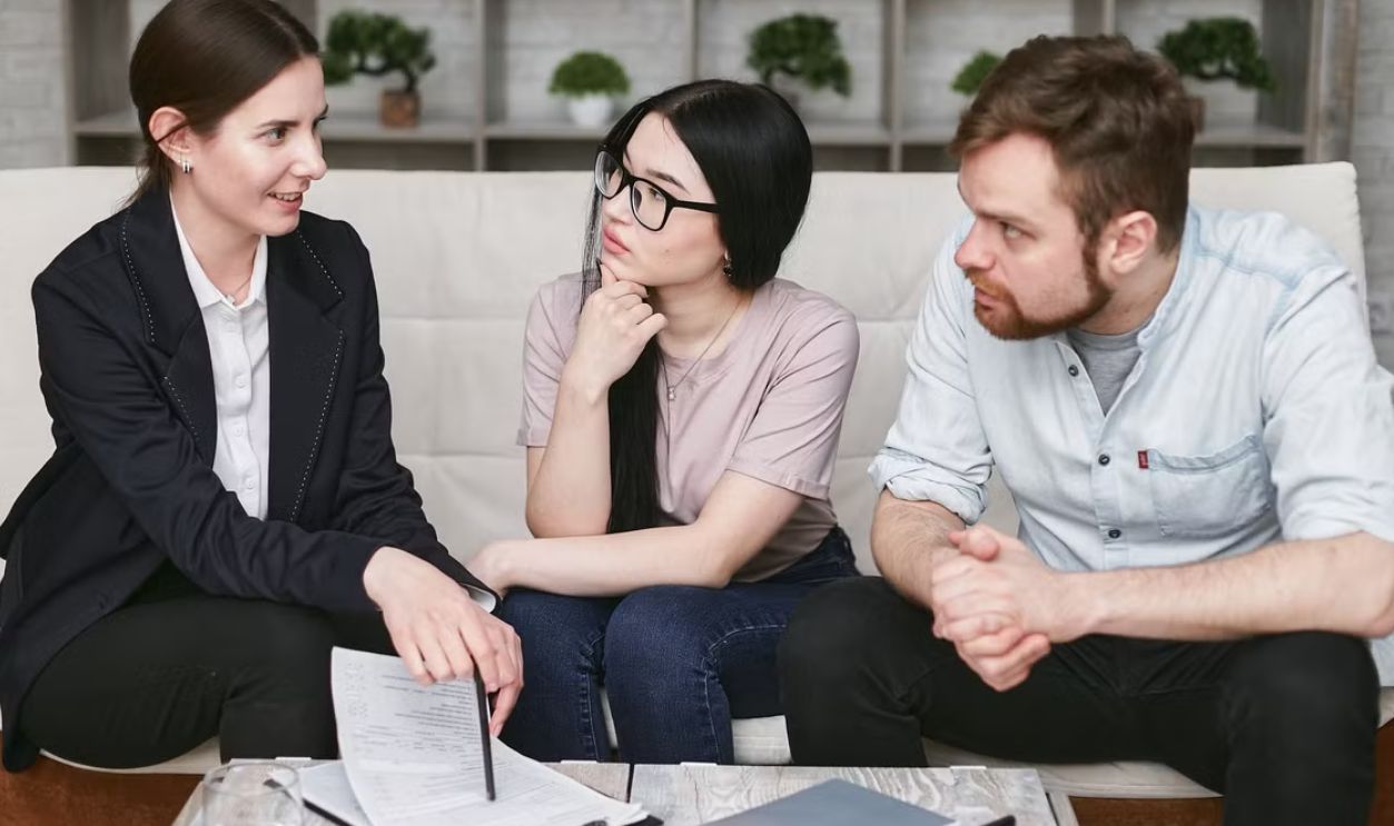 Three adults discussing business inside, focused on cooperation and strategy
