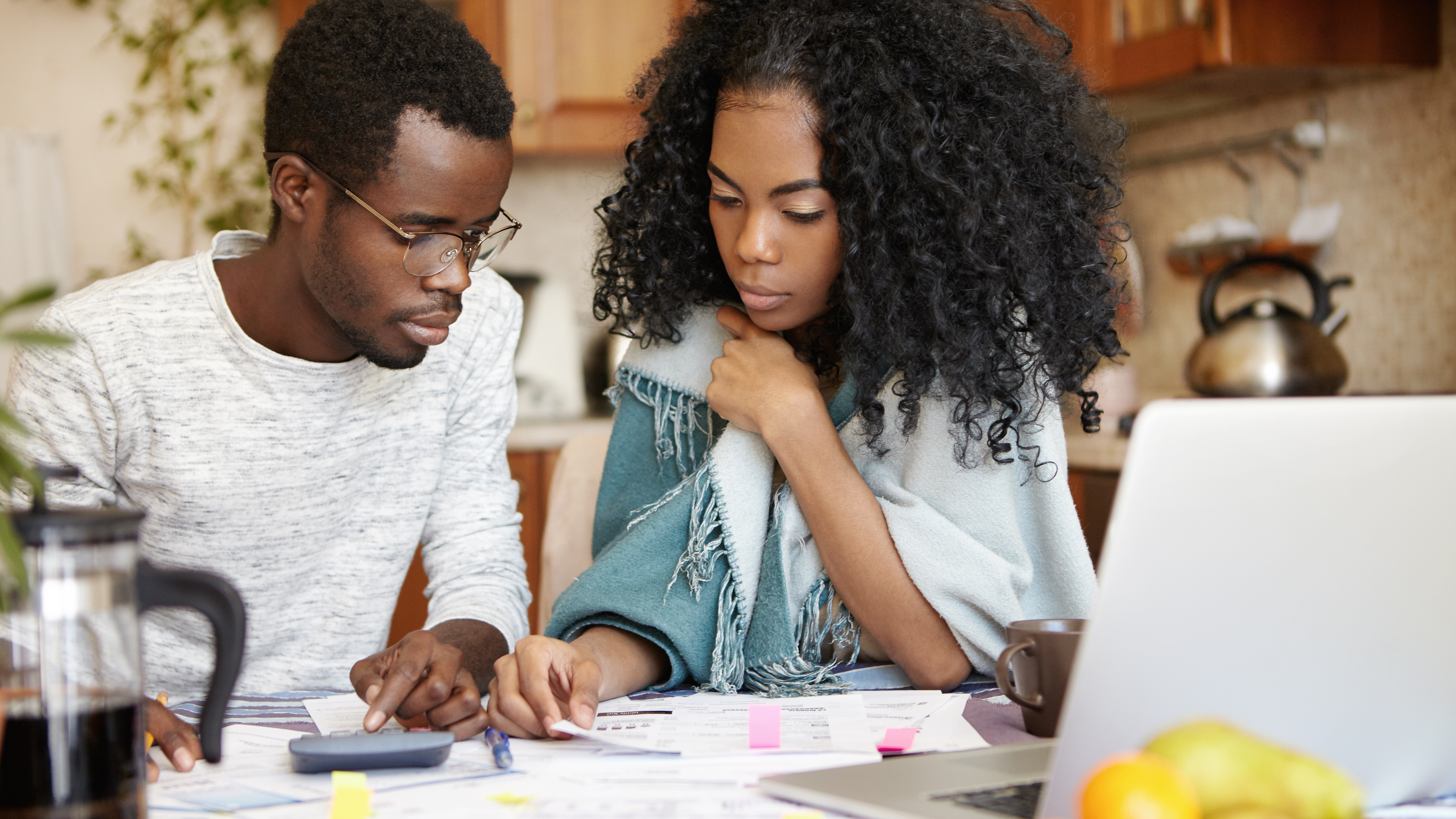 A couple doing paperwork together, calculating domestic expenses and planning family budget