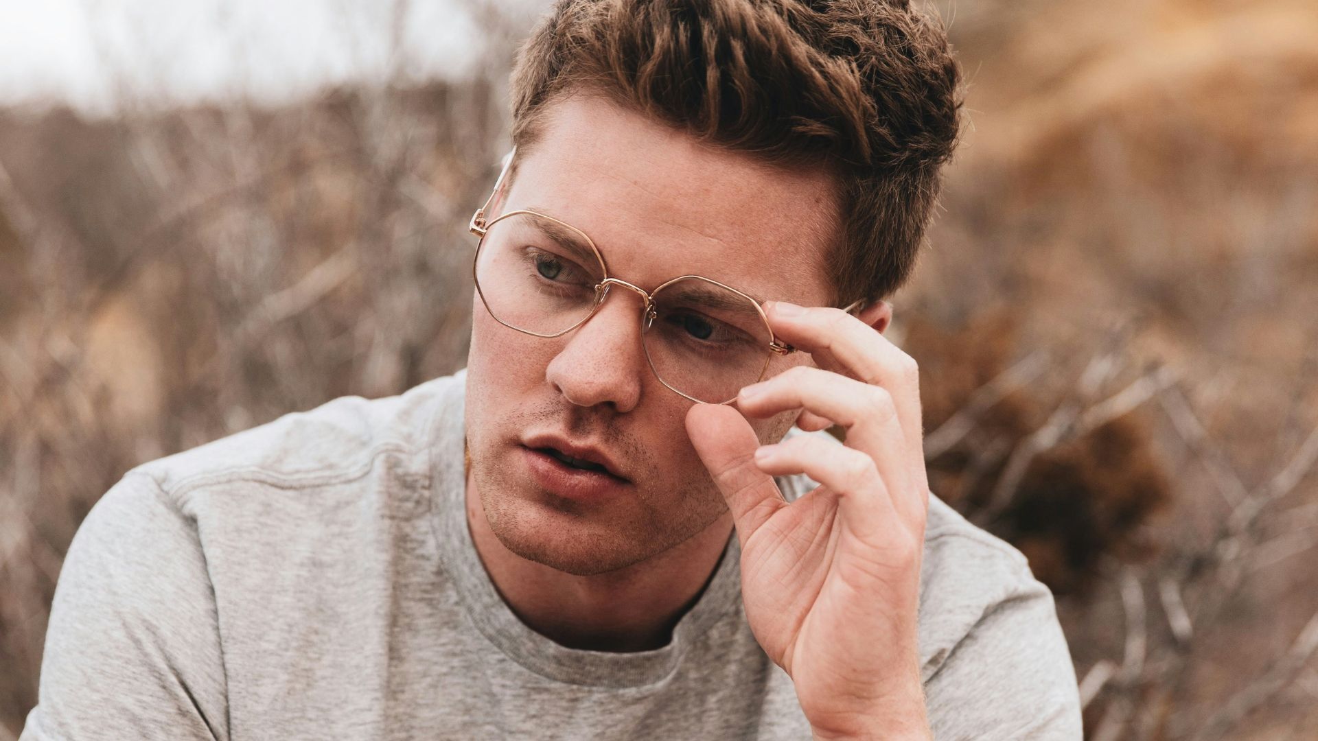 man in gray crew neck t-shirt wearing black sunglasses
