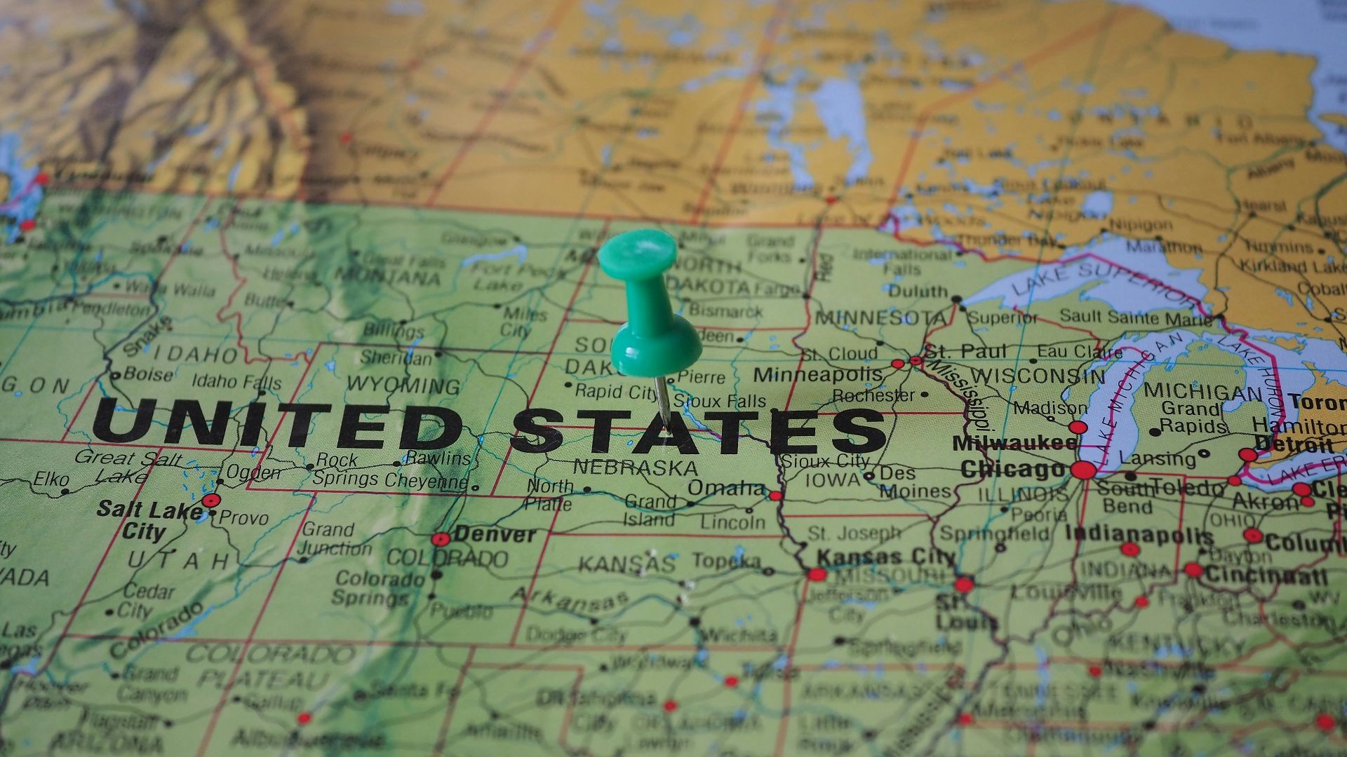 High-angle view of a map featuring the United States with a green pin indicating a specific location.