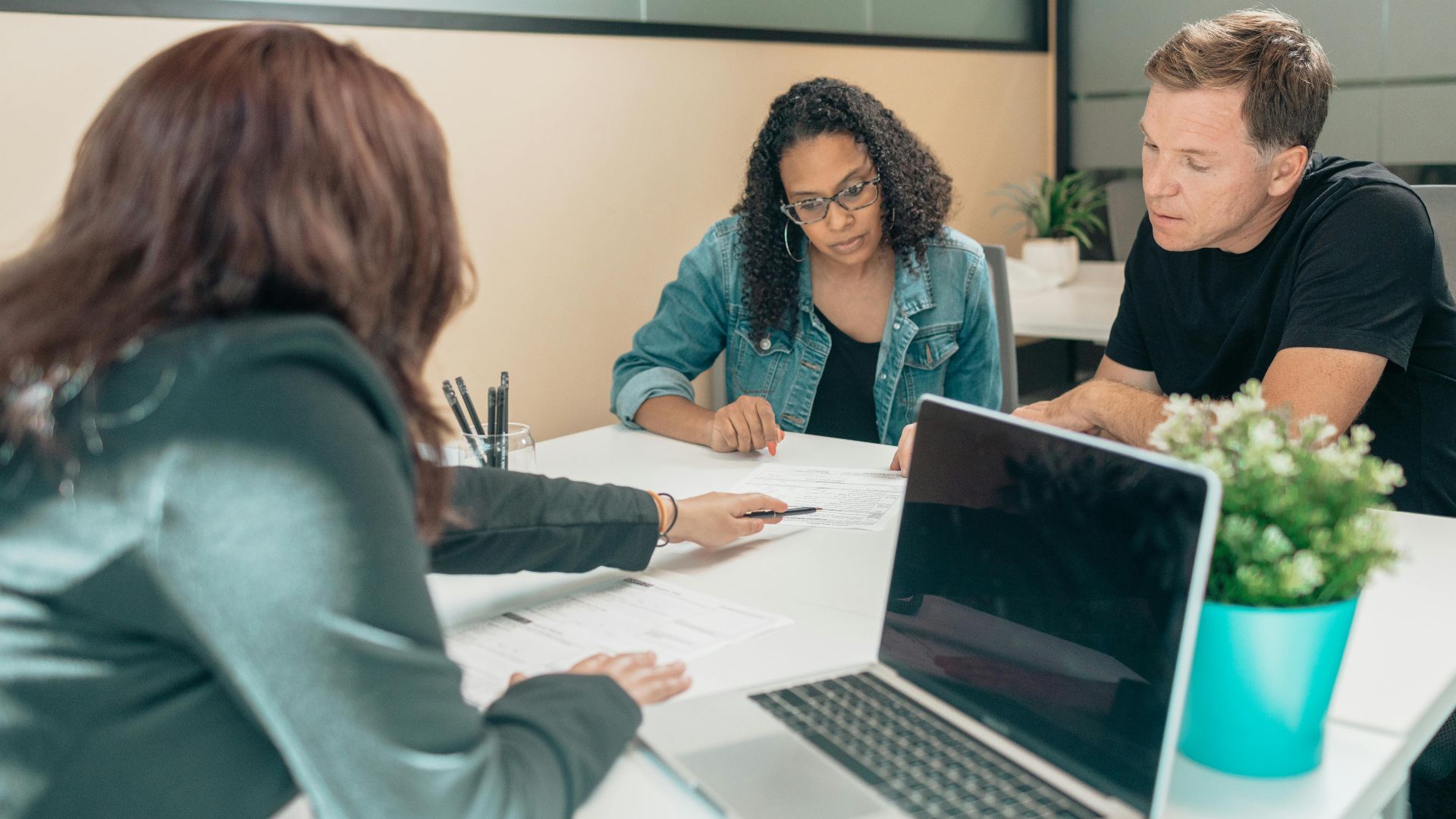 Couple meeting with advisor for adoption process in a modern office setting.