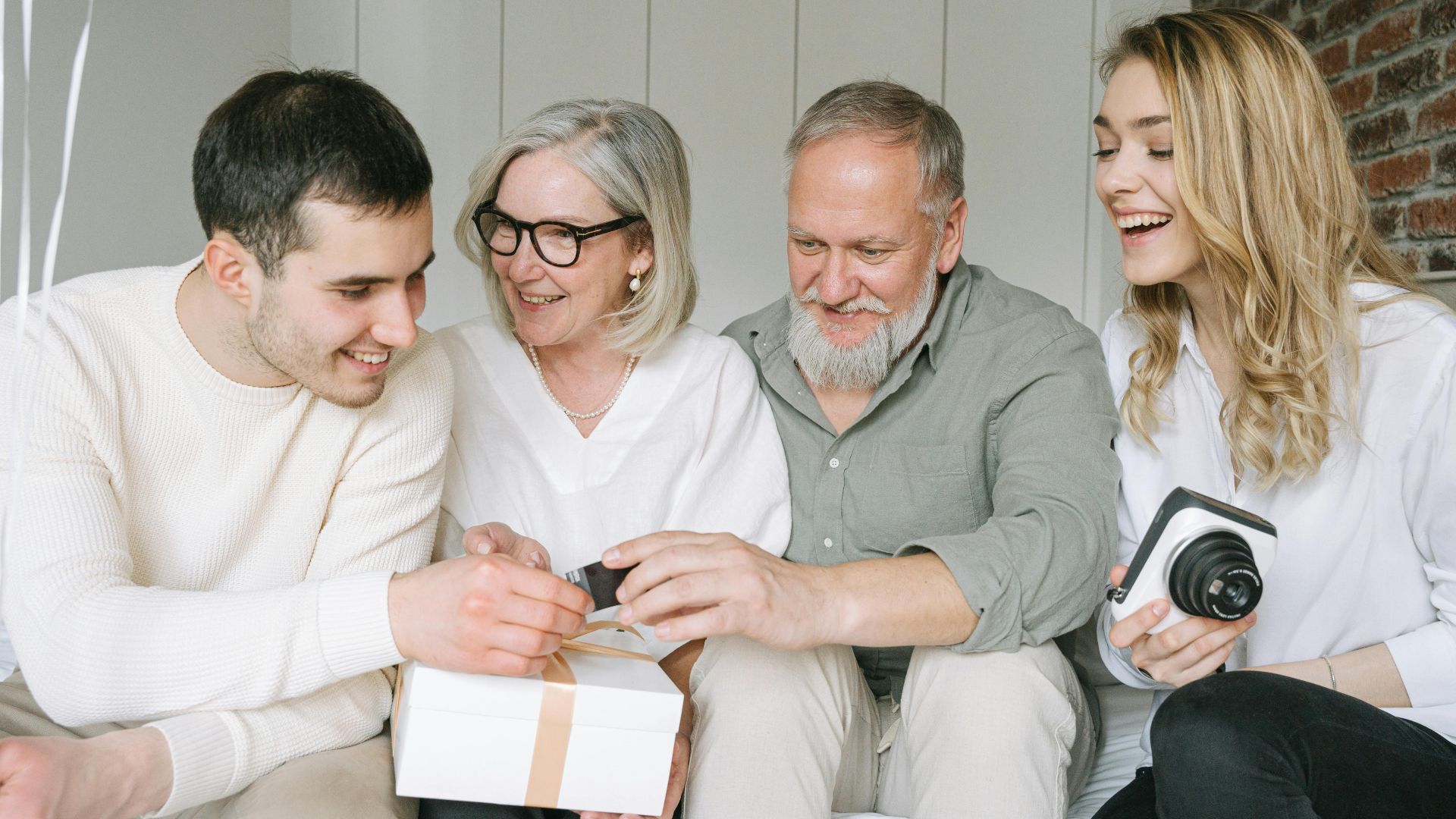 Happy family exchanging gifts together, capturing a joyful moment indoors.