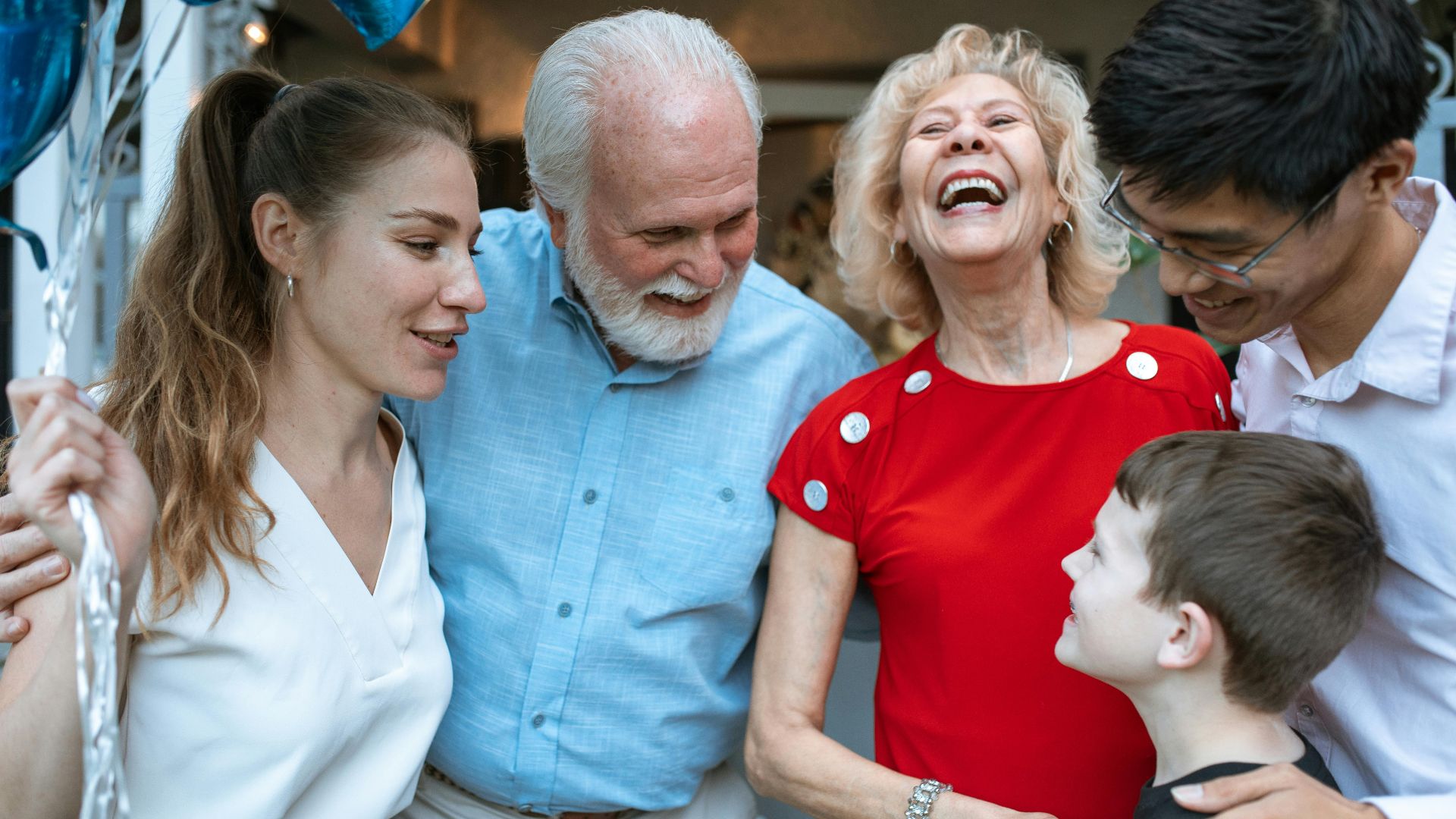 A joyful family gathering with diverse generations sharing a light moment outdoors.