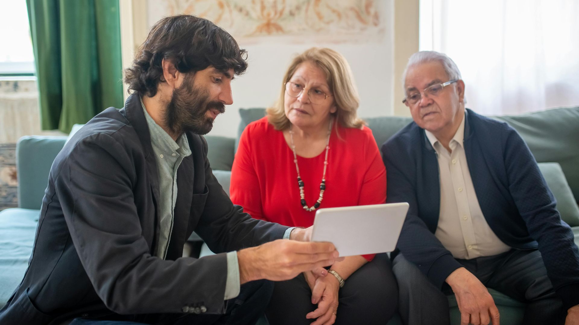 A financial advisor discussing investment options with an elderly couple in a cozy living room.