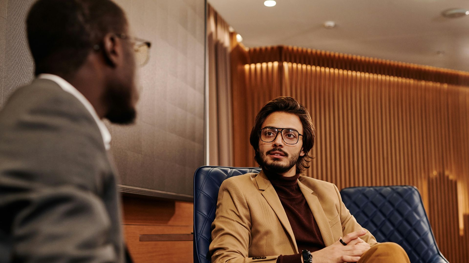 Two businessmen in a corporate setting engaged in discussion, fostering collaboration.