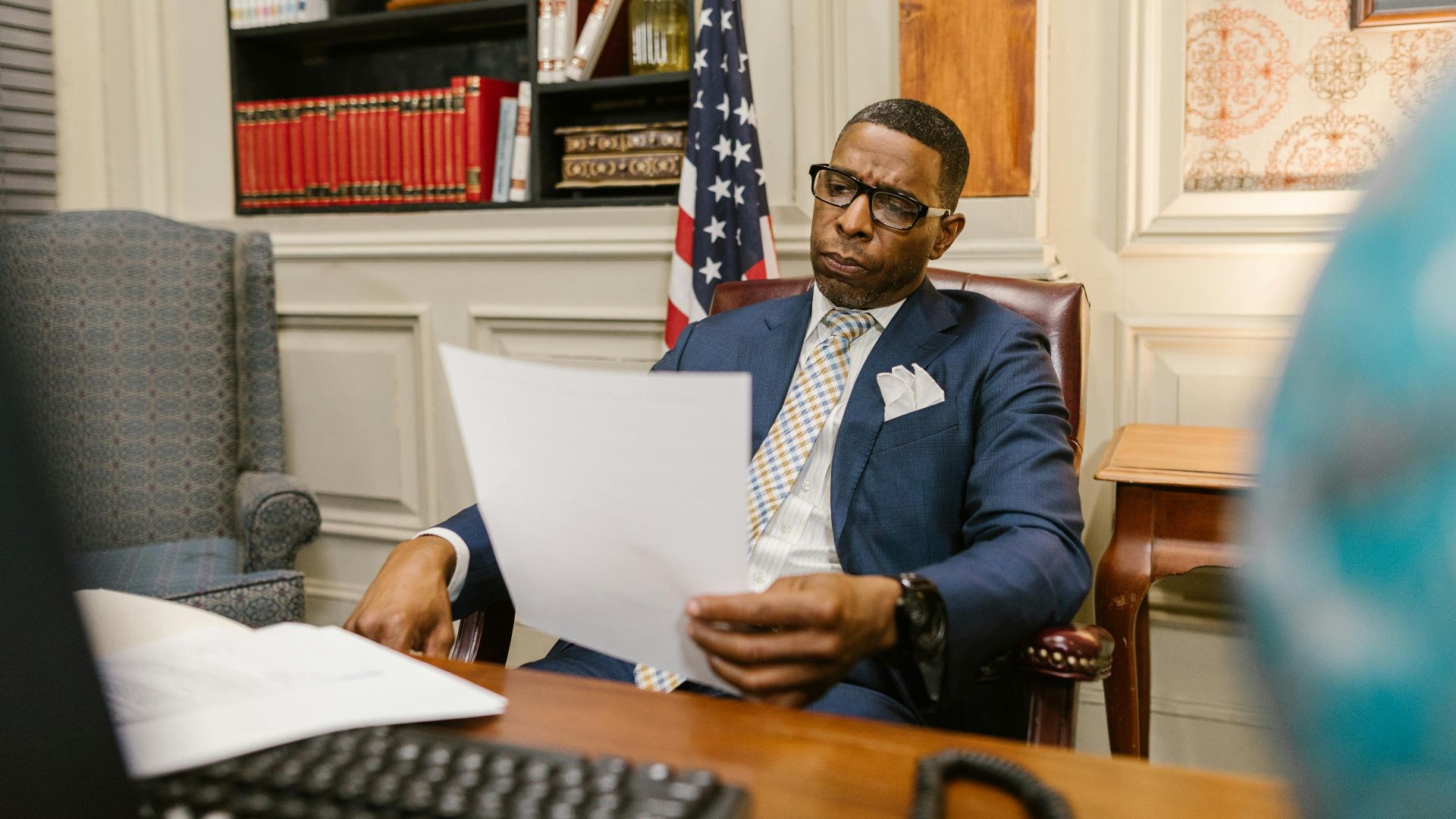 A lawyer attentively reviewing documents at his desk in a law office setting.