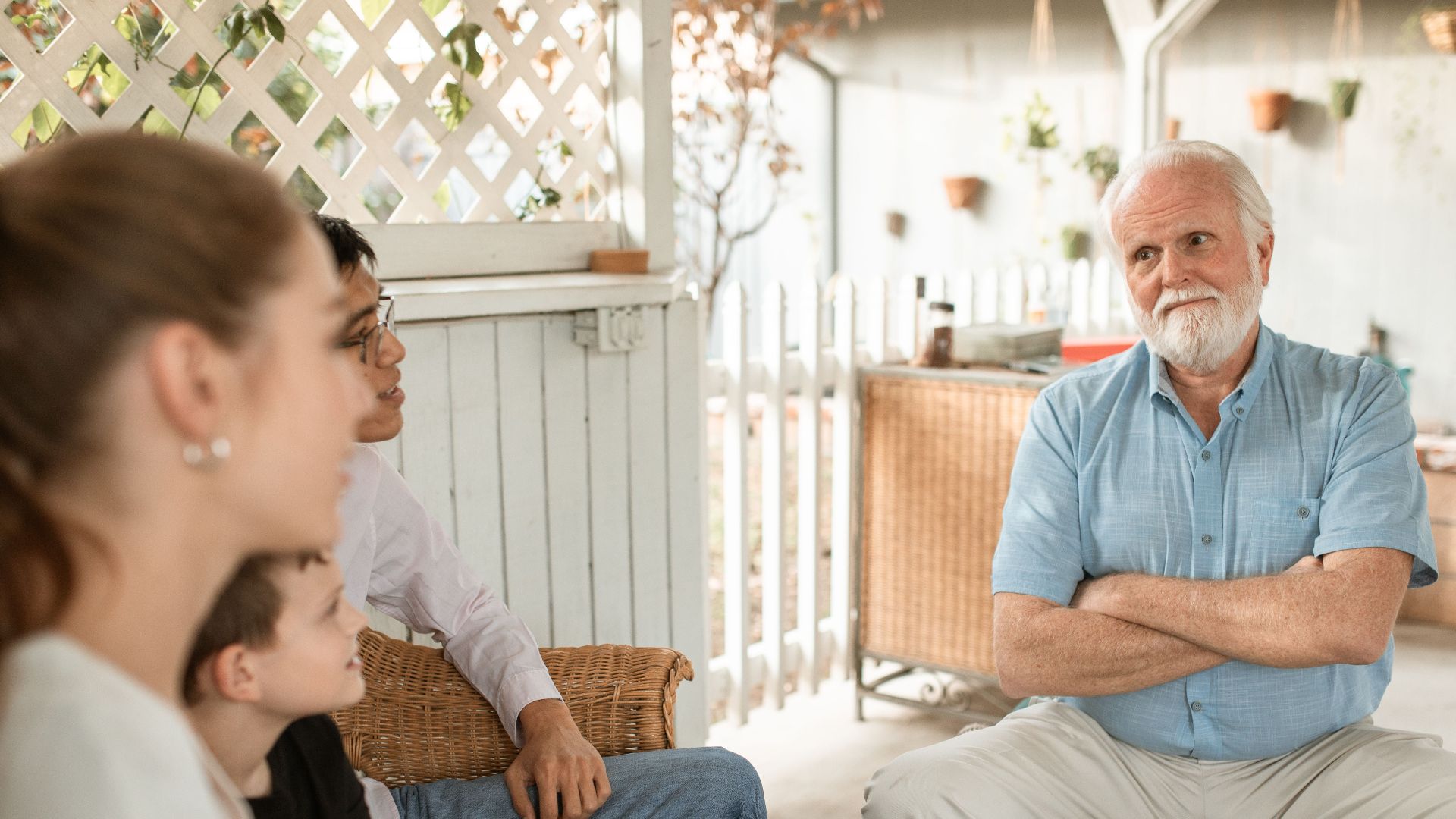 Family gathered indoors, engaged in conversation with a focus on bonds and togetherness.