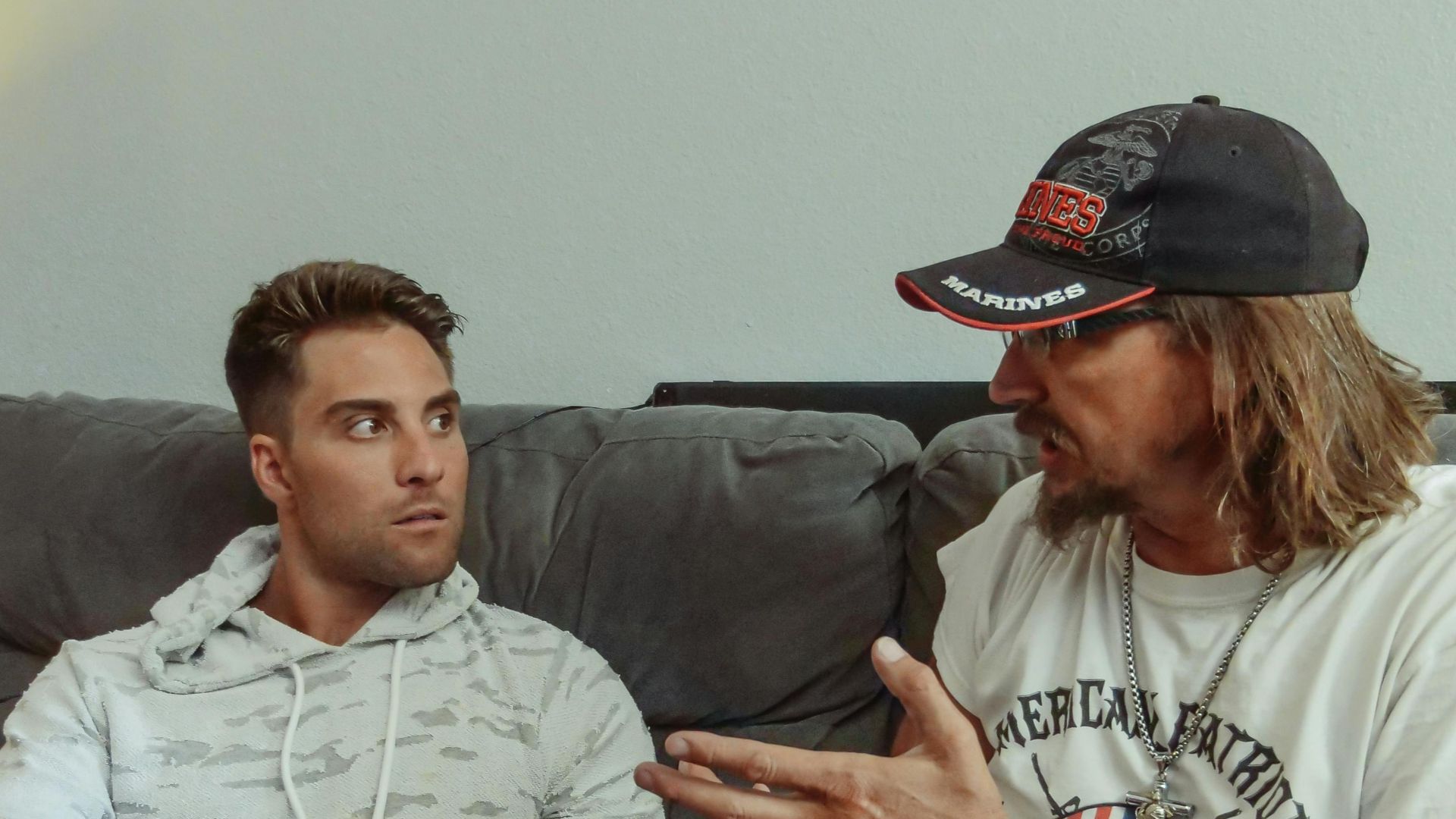 Father and son engaging in a deep conversation while sitting on a cozy sofa indoors.
