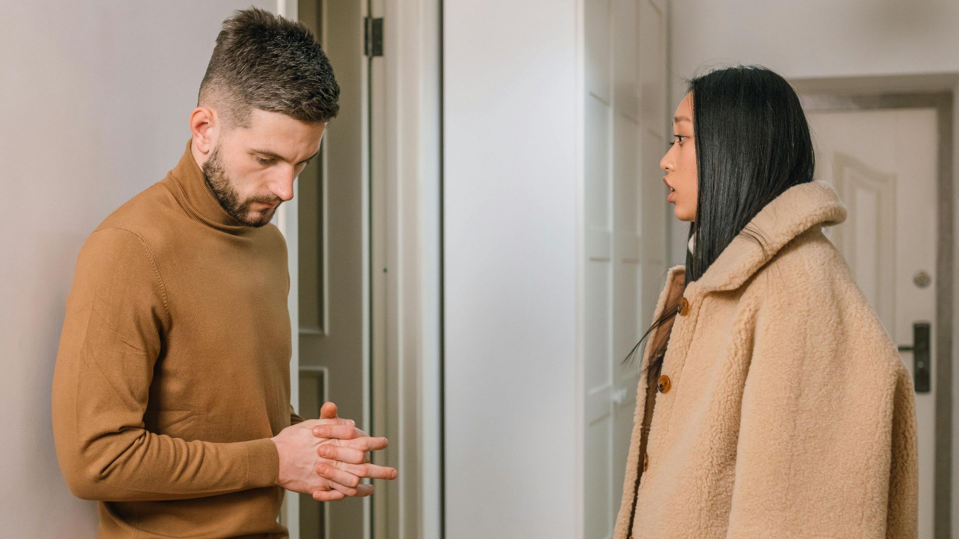 A man and woman having a serious discussion indoors, portraying relationship tension.