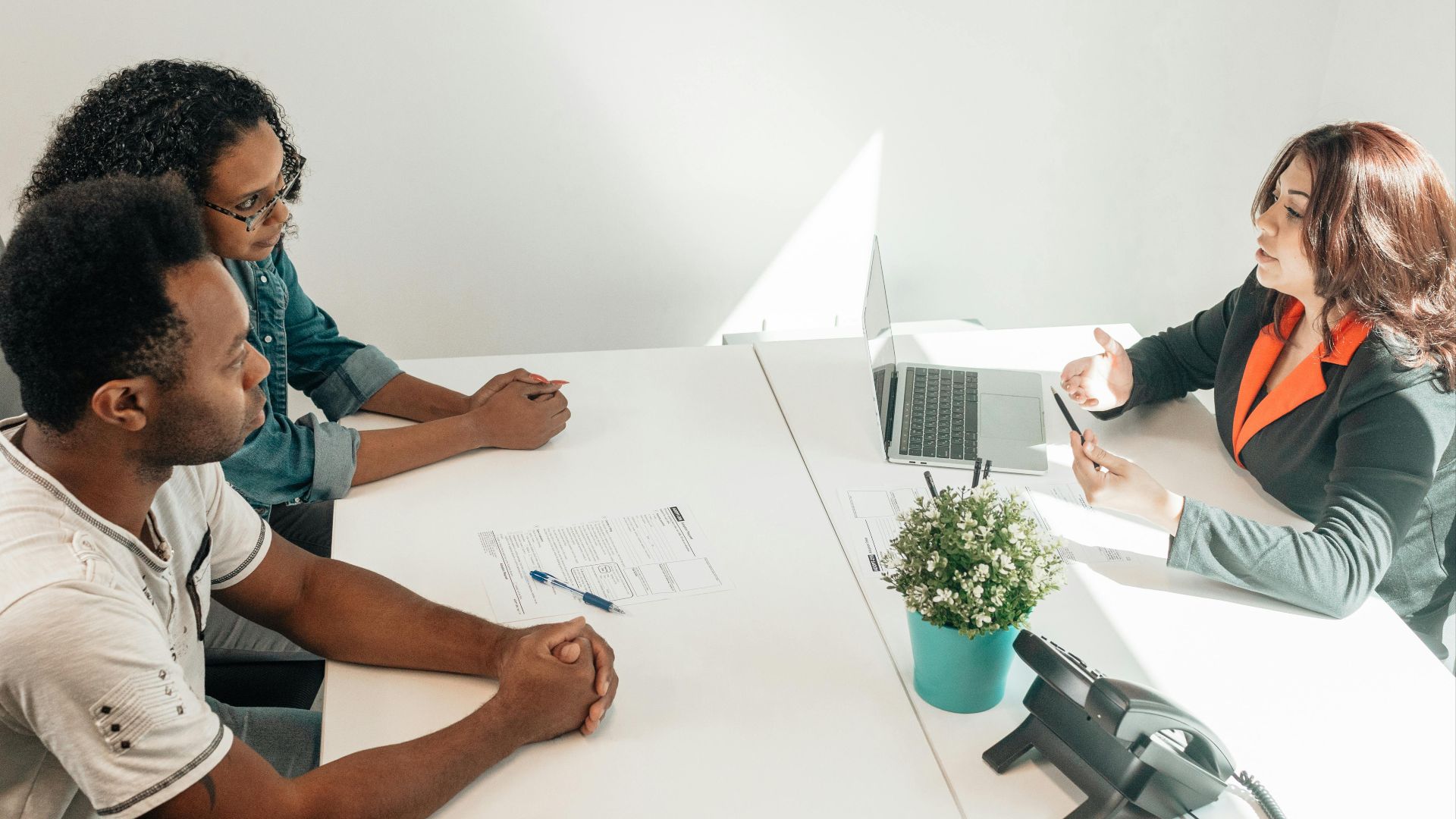 Two adults consulting a legal advisor in a modern office setting.