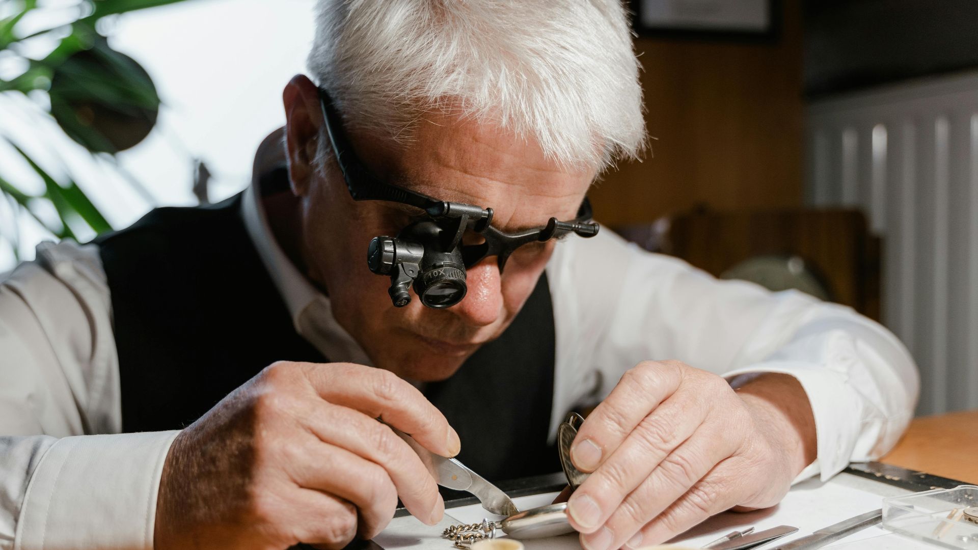 A watchmaker meticulously repairing a pocket watch with precision tools and a magnifier.