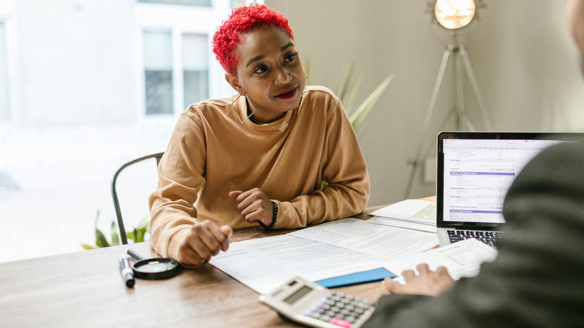 Professional woman engaged in thoughtful discussion at a business meeting indoors.