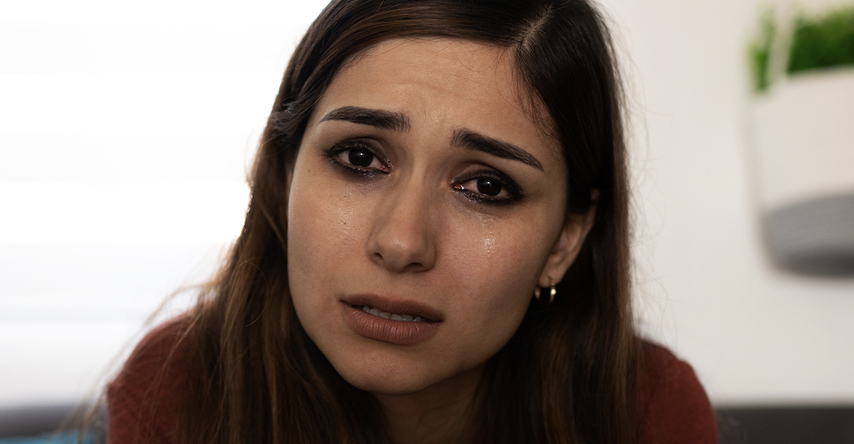 Crying woman, making eye contact with the viewer.