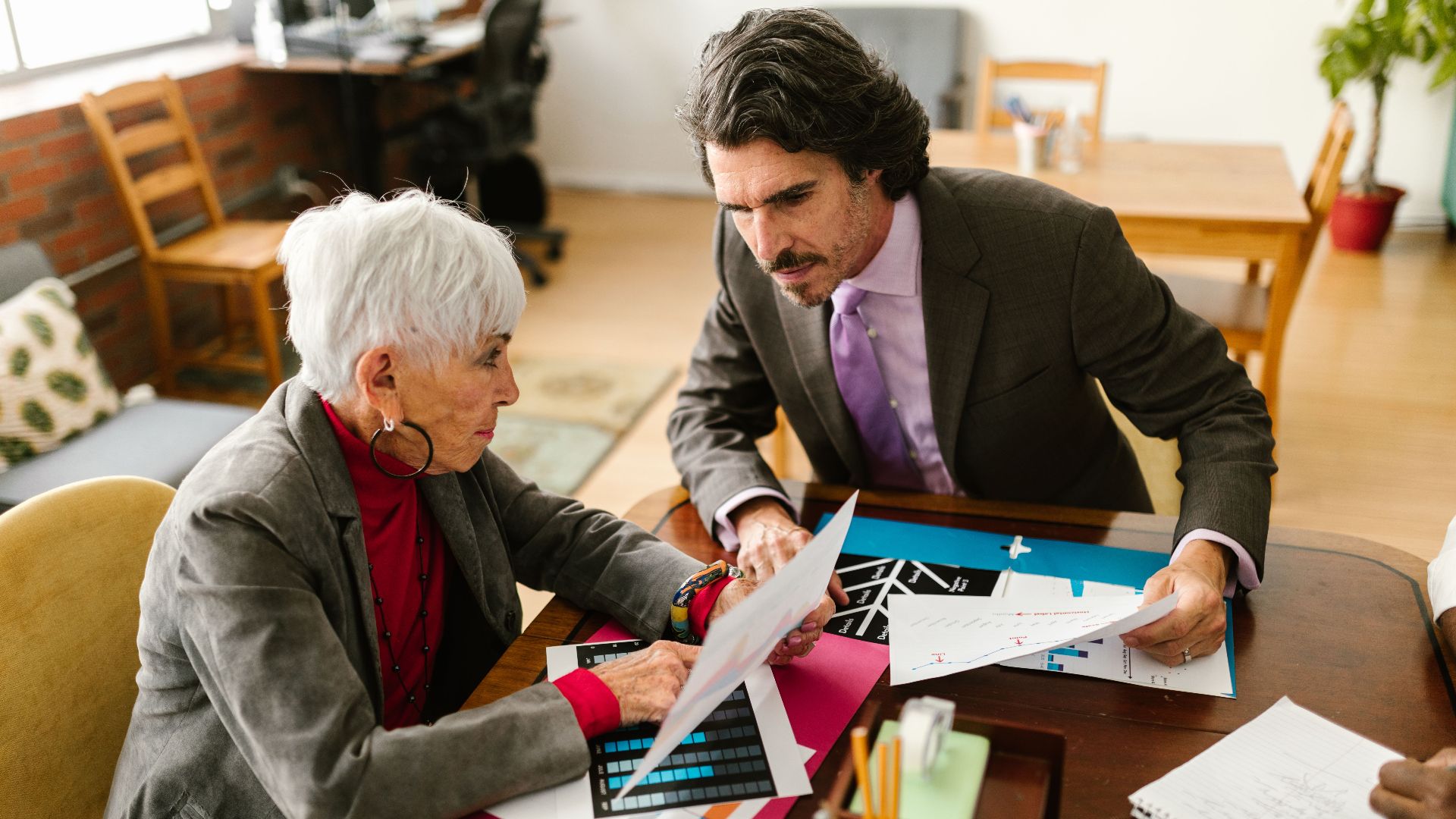 Senior colleagues engaged in a business meeting discussing documents at the office.