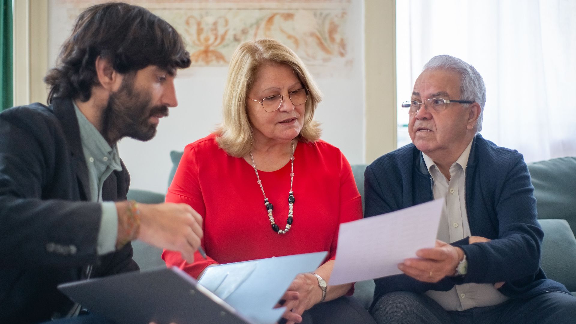 Senior couple consulting with a professional advisor, discussing documents indoors.