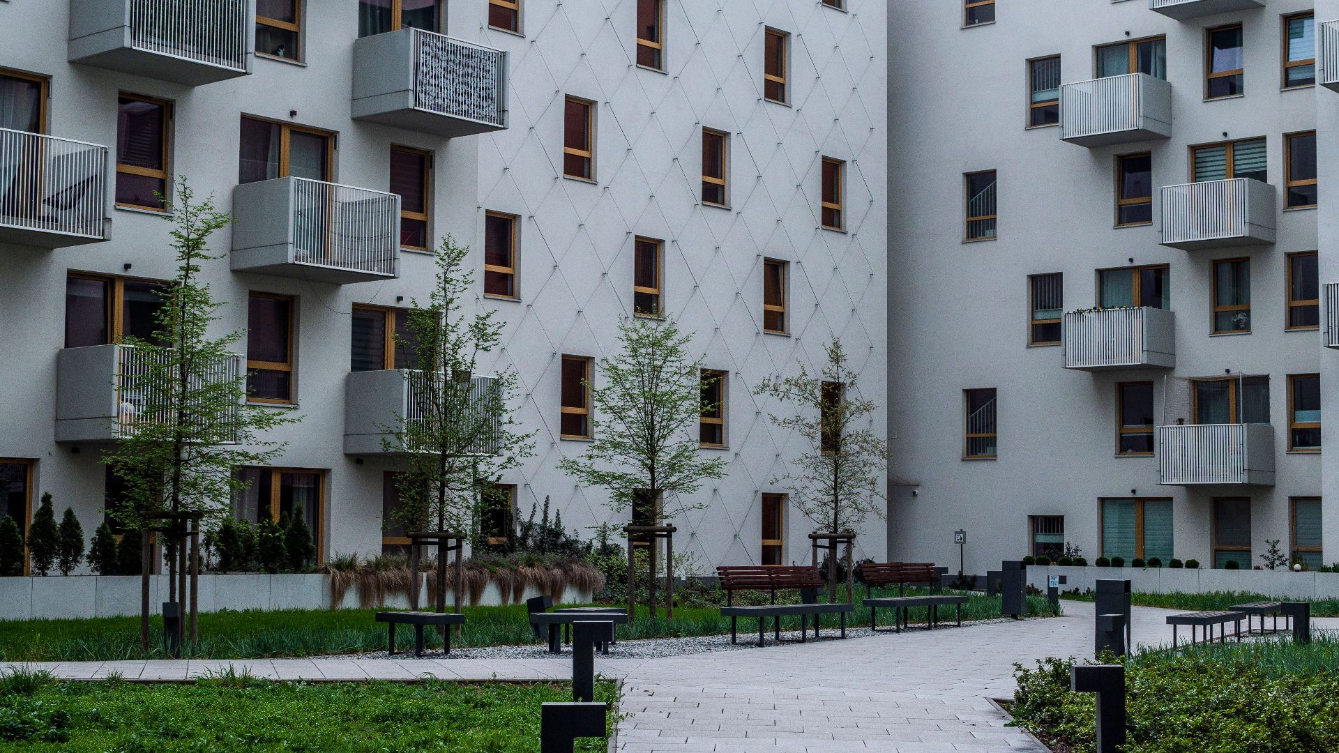 Contemporary apartment complex with landscaped courtyard and balconies.