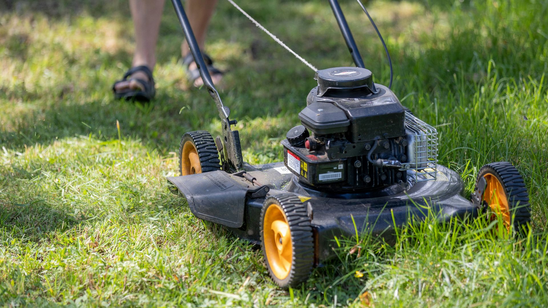 a person mowing the grass with a lawn mower