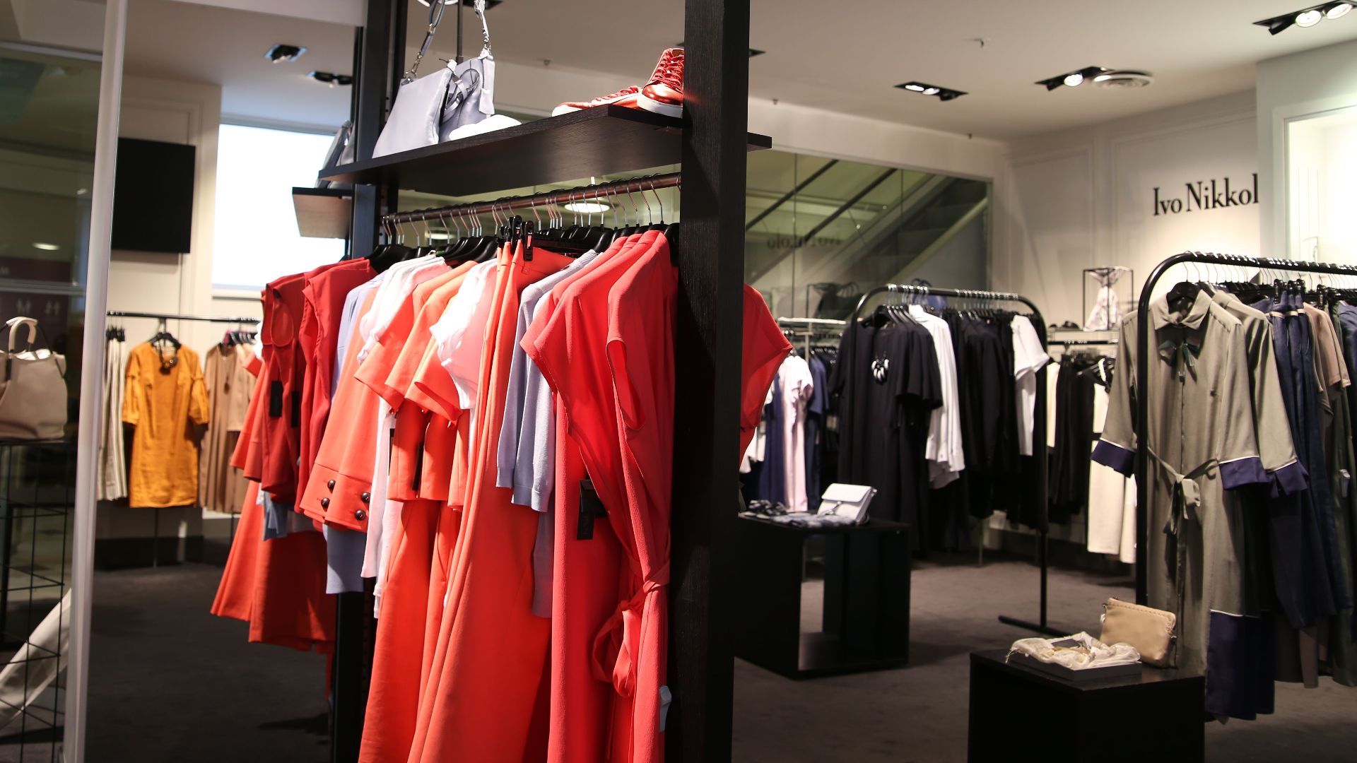Discover a chic fashion boutique showcasing a variety of colorful clothes on elegant racks.