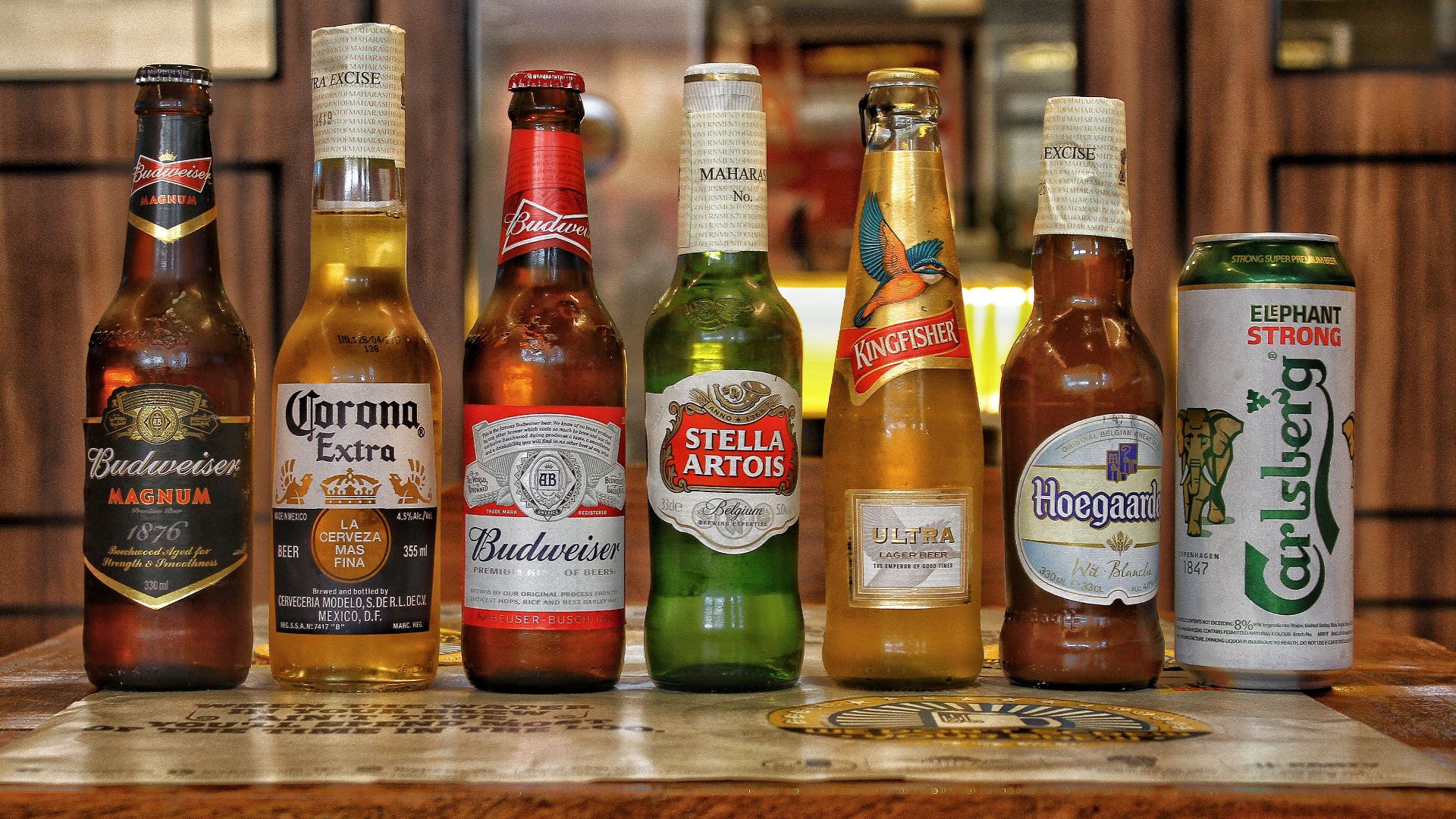 Collection of international beer bottles displayed on a bar counter.