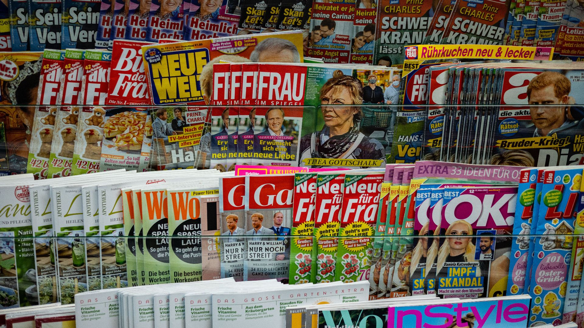 A vibrant display of magazines in a newsstand, showcasing various colorful covers and headlines.