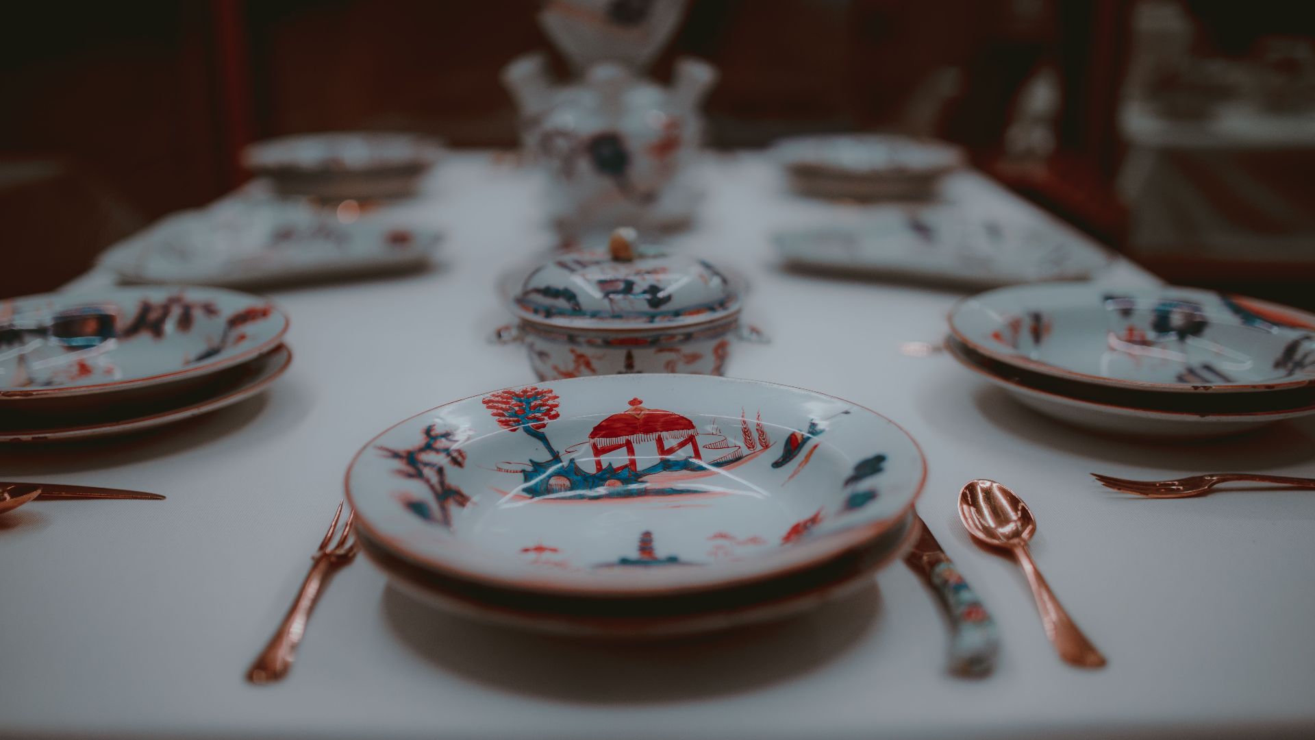 Close-up of a sophisticated porcelain place setting with intricate designs on a dining table.