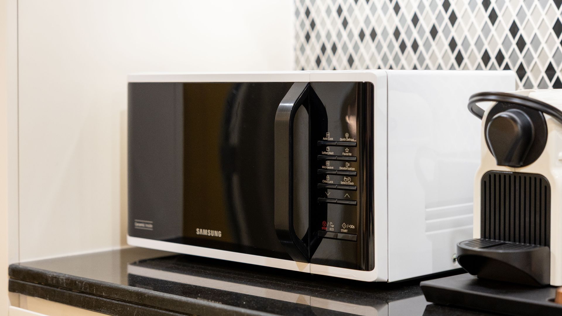 Stylish kitchen setup featuring a black microwave and coffee maker on a counter.