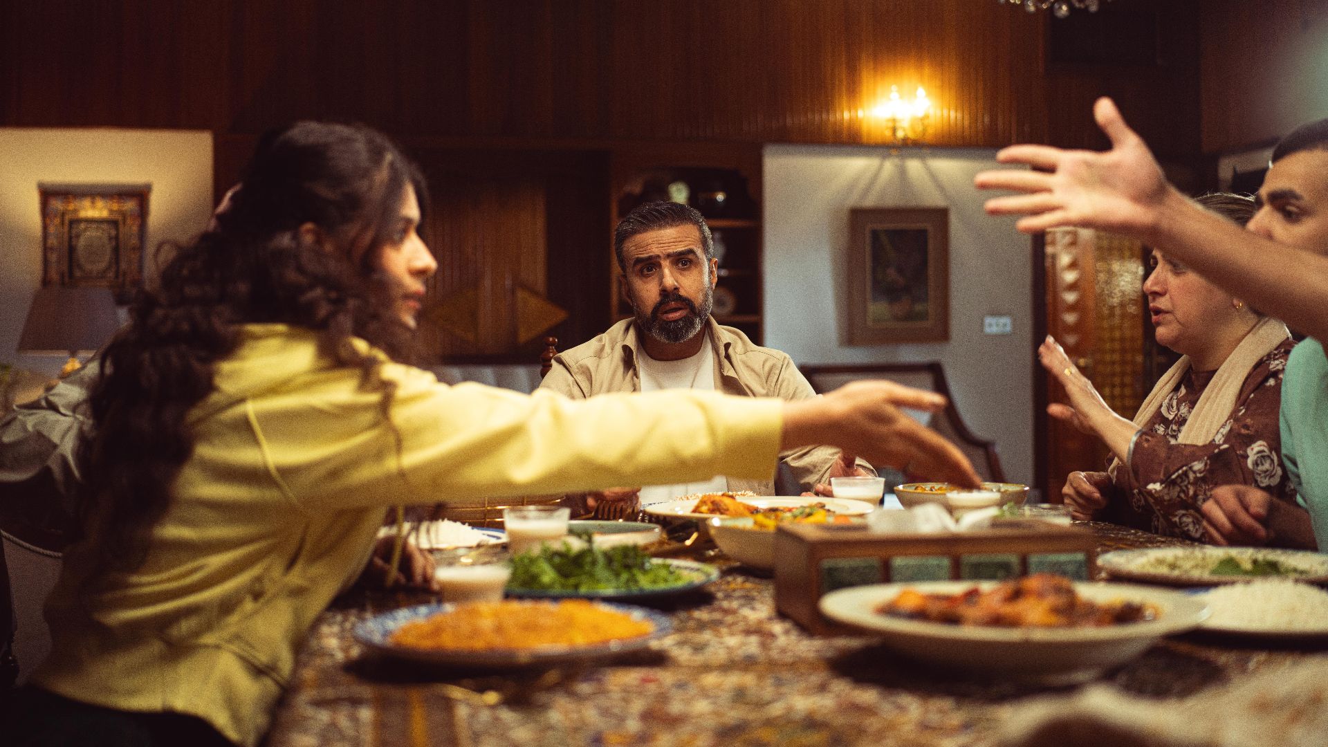 A lively family dinner with diverse group enjoying a meal and engaging in conversation.